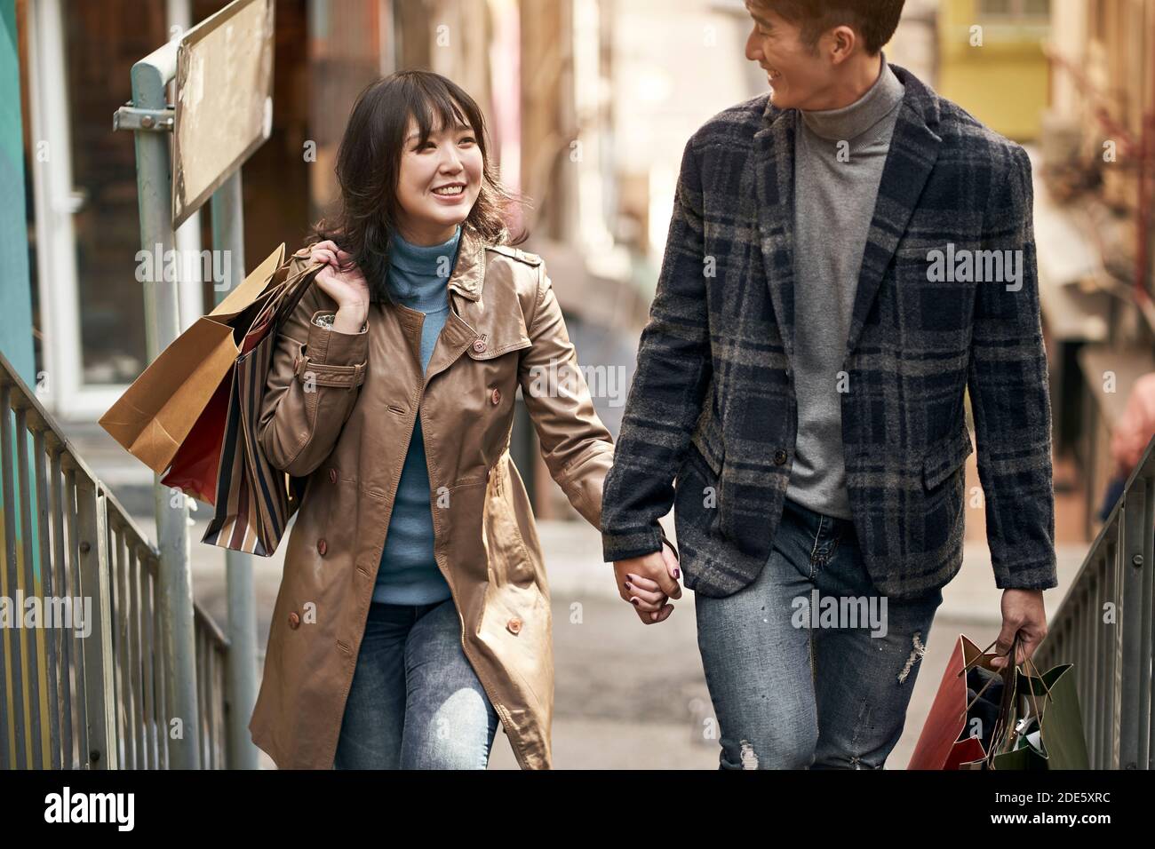Glücklich junge asiatische Paar zu Fuß sprechen Hände halten beim Einkaufen In der Stadt Stockfoto