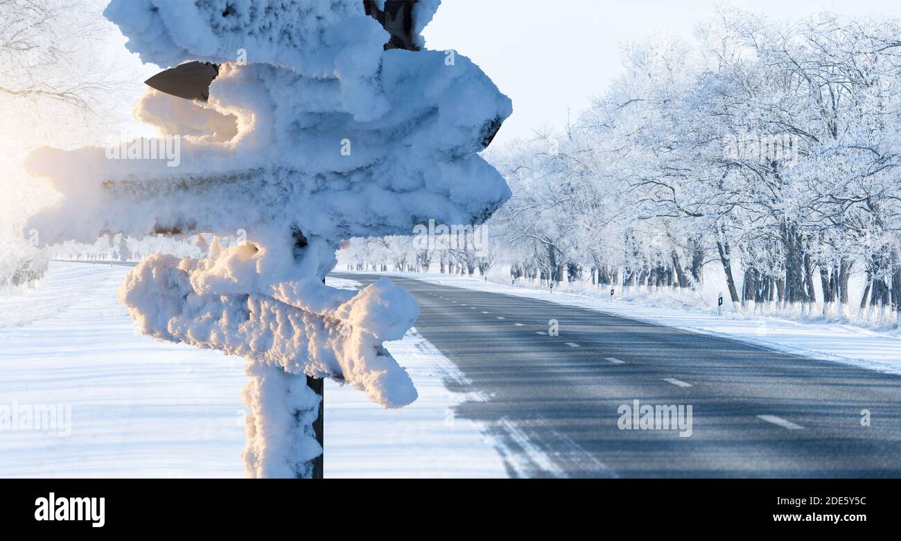 Schneebedecktes Schild mit Holzpfeilen. Reisen im Winter Stockfoto