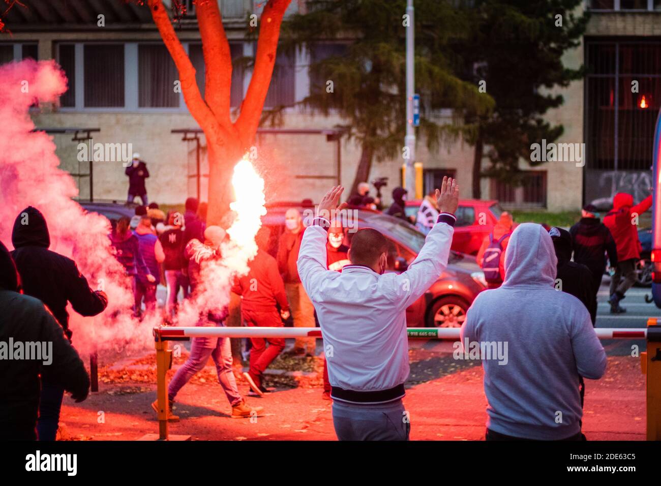 Wütende Menschen tun Handgesten mit roten Fackeln auf Slowakisch Anti-Regierungs-Demonstration gegen Einschränkungen durch Corona-Viren Stockfoto