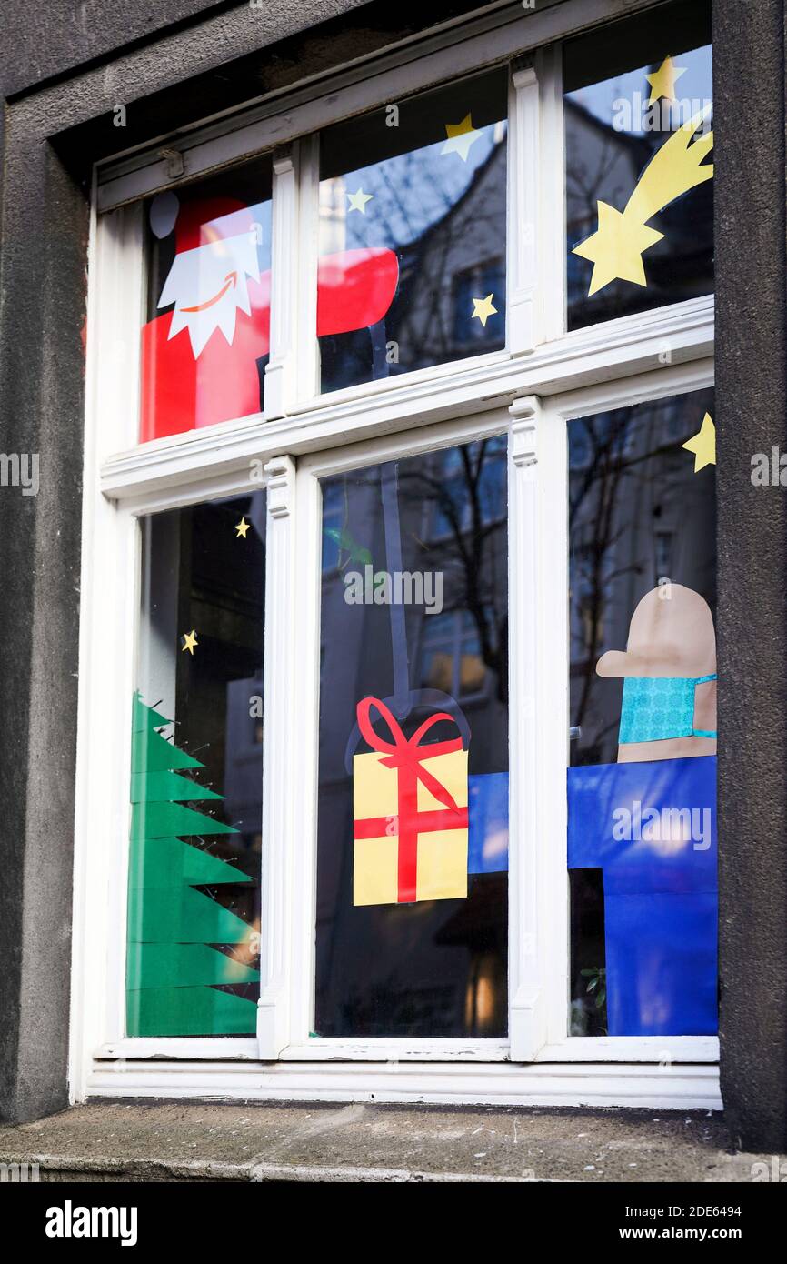 Dortmund, 29. November 2020: Nikolaus mit dem Amazon-Logo als sein Mund das Paket liefert, trägt der gebende Mann Mund- und Nasenschutz gegen das Virus. Apartment Fenster für Weihnachten geschmückt zeigt Heiligabend in Corona Zeiten. Stockfoto