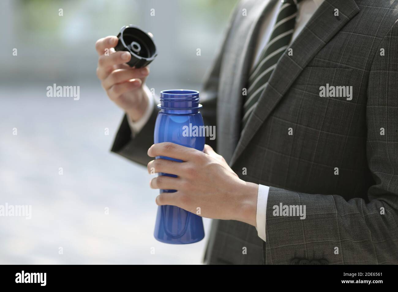 Nahaufnahme eines Geschäftsmannes, der eine Flasche Wasser hält Stockfoto