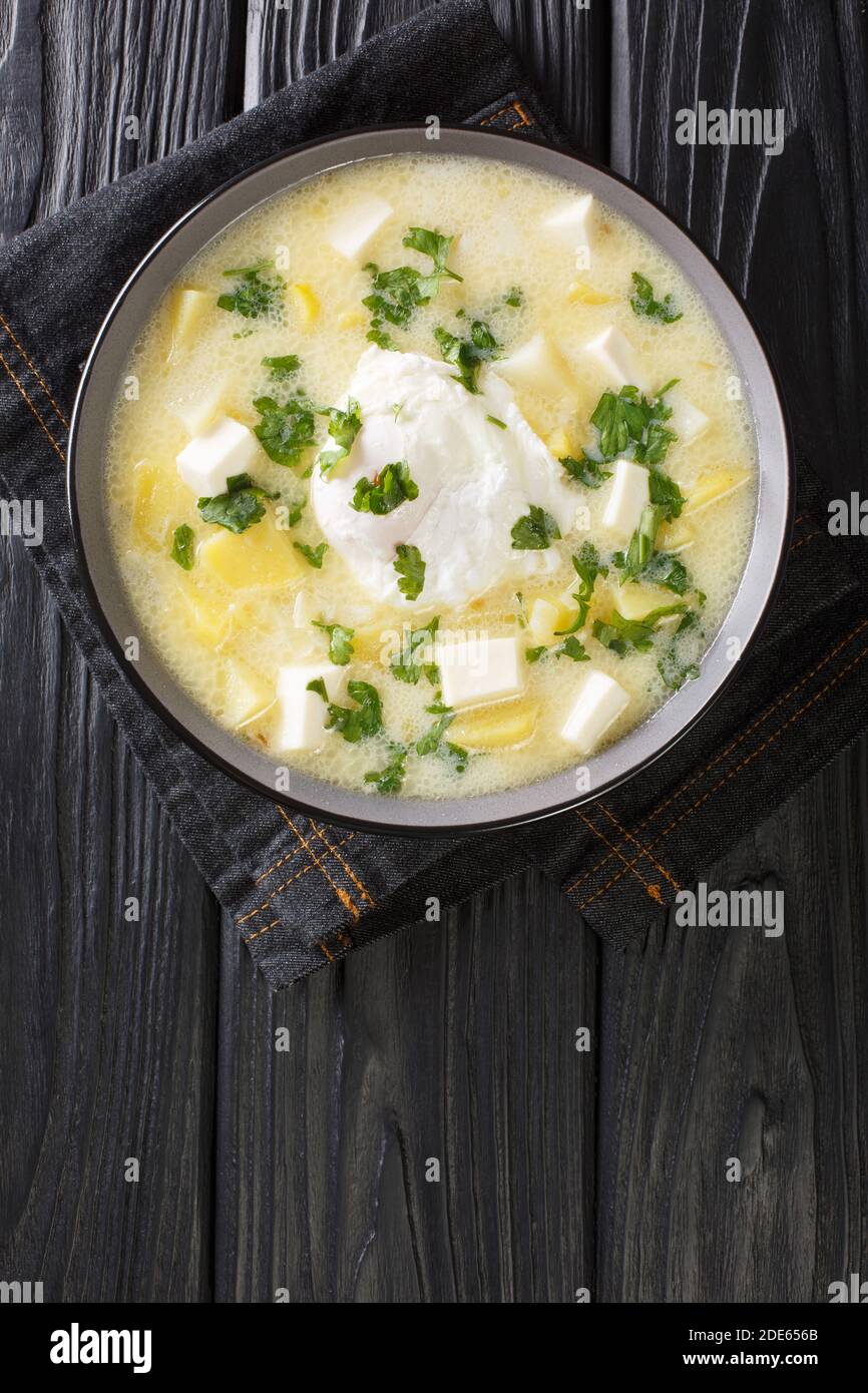 Pisca Andina ist eine Suppe, die normalerweise mit Hühnerbrühe, gewürfelten Kartoffeln und Eiern zubereitet wird und dann mit Weißkäse und Koriander in einer Schüssel auf t garniert wird Stockfoto