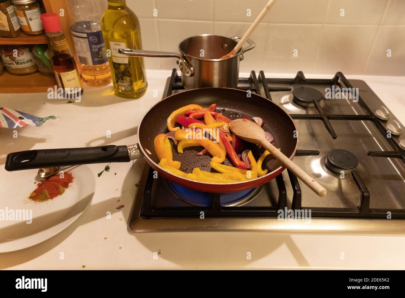 Ein mexikanisch inspiriertes Gericht – Paprika und Zwiebeln in einer Mischung aus Gewürzen braten. Stockfoto