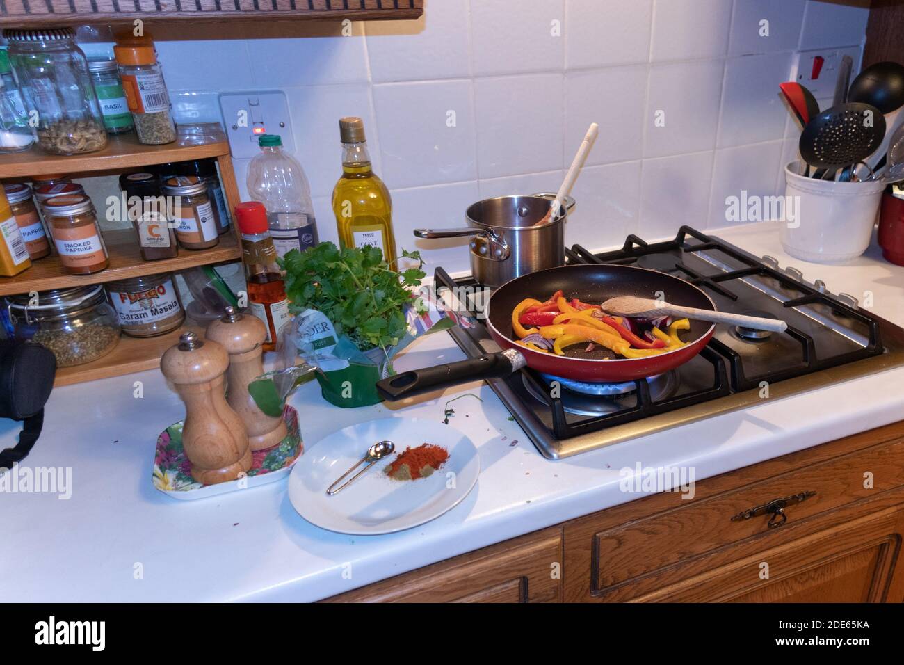 Ein mexikanisch inspiriertes Gericht – Paprika und Zwiebeln in einer Mischung aus Gewürzen braten. Stockfoto