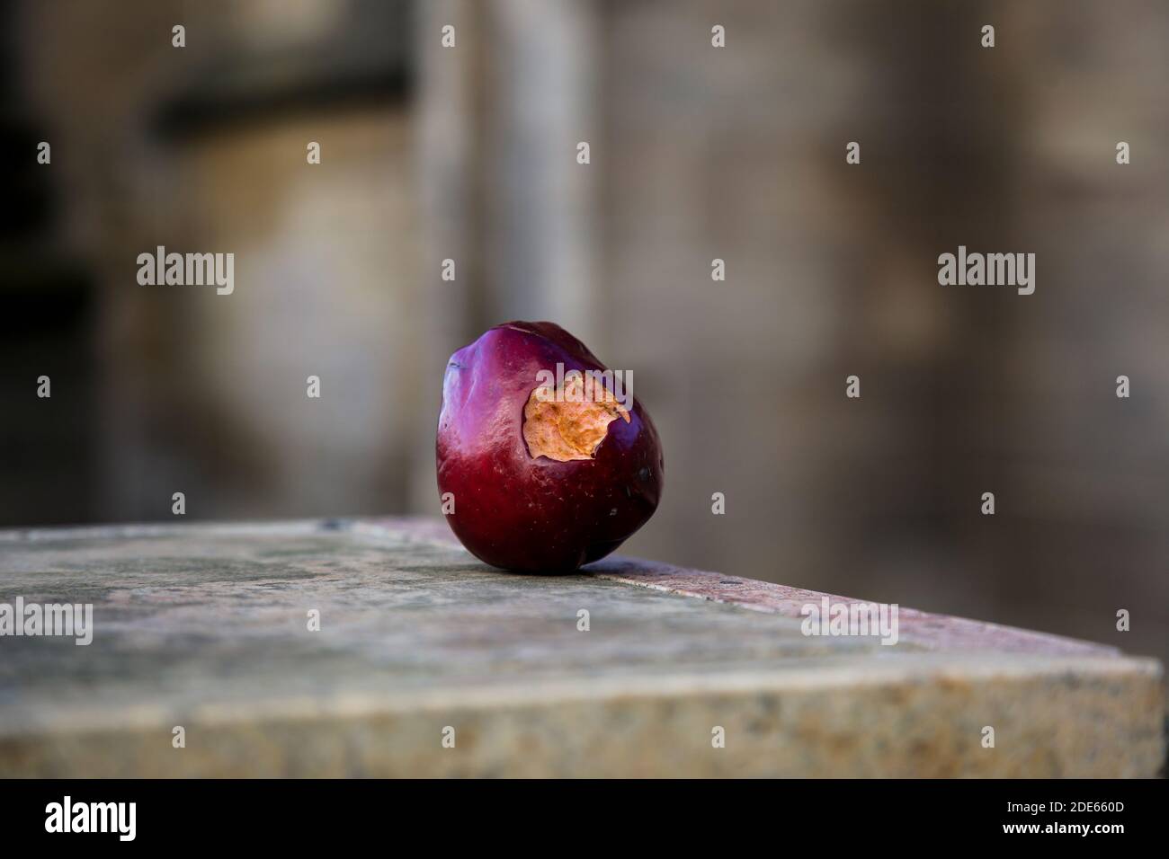 Rot gebissen Apfel links an einer Wand in der Straße Stockfoto