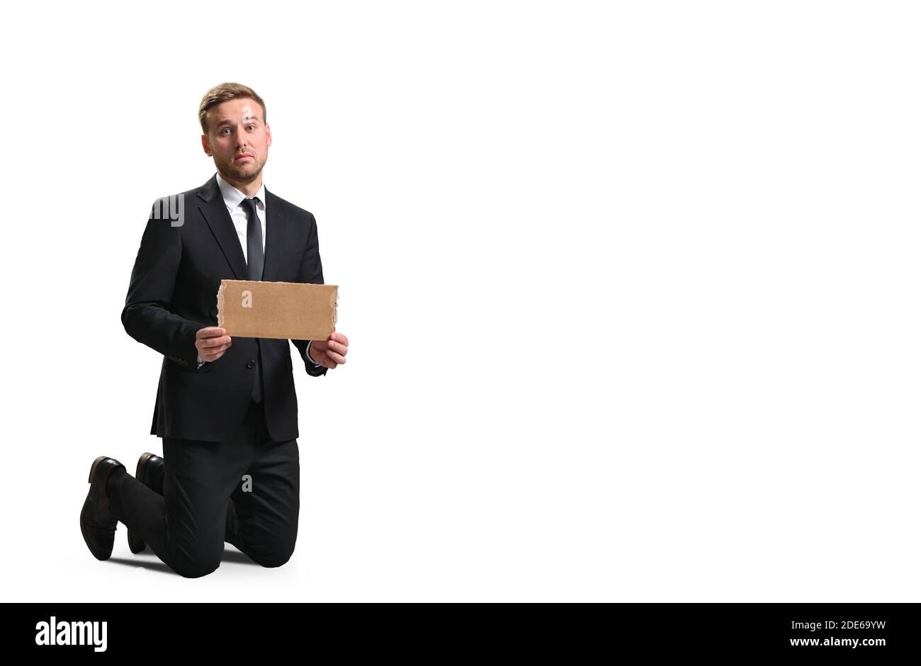 Entlassene Manager zeigt leeres Pappplakat auf weißem Hintergrund, Arbeitslosigkeit und Armut Stockfoto