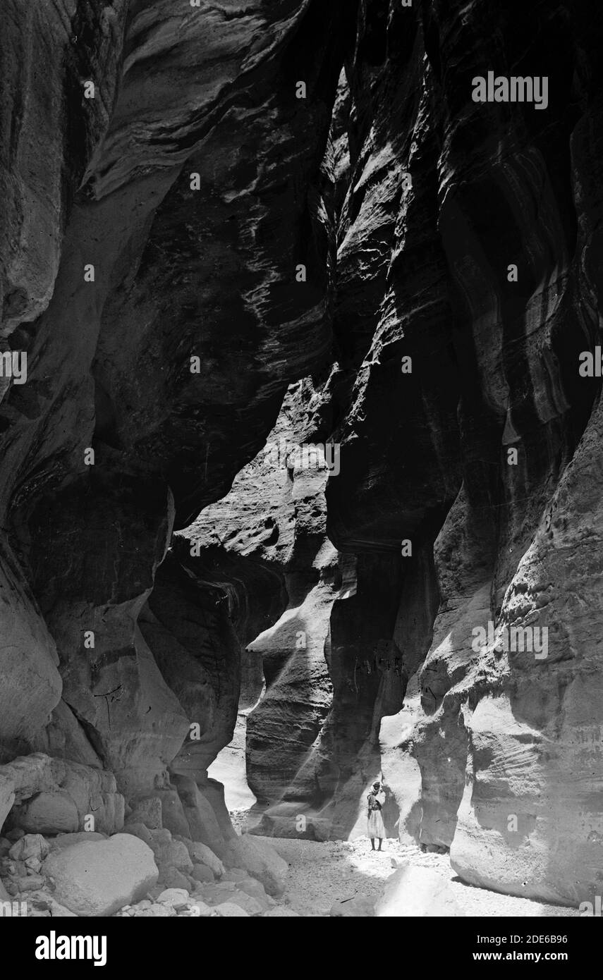 Bildunterschrift: Petra (Wadi Musa). In es-Siq. Zeigt überhängende Klippen mit Sonnenlicht, das durch den Graben filtert - Ort: Petra Jordan Ca. 1920 Stockfoto