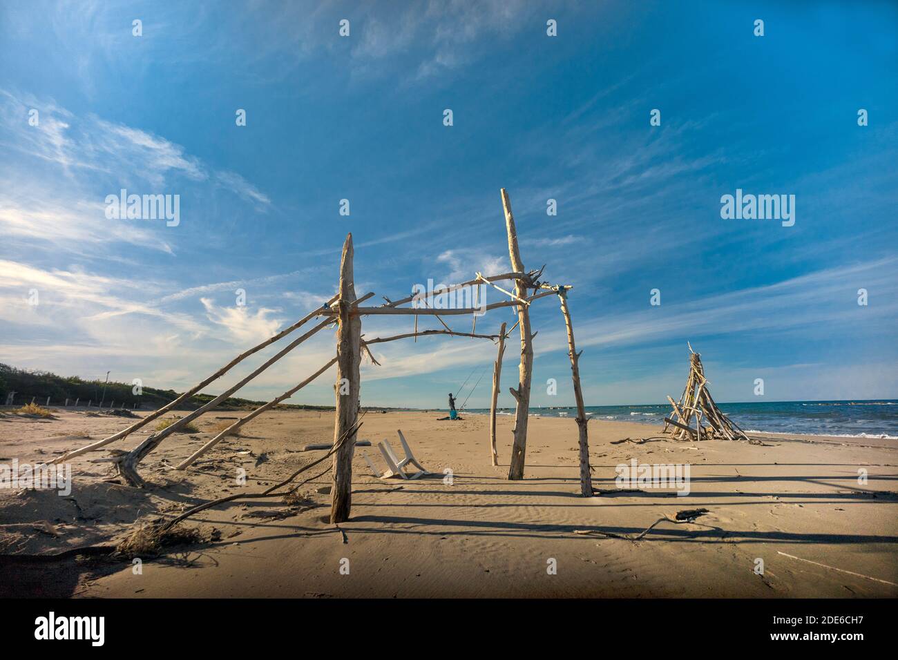 Campomarino, Molise, Italien: Struktur einer alten Hütte am Strand mit einem Fischer im Hintergrund Stockfoto
