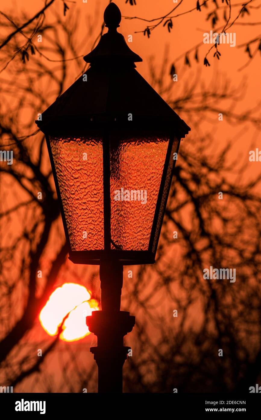 Xanten, NRW, Deutschland. November 2020. Die Sonne geht hinter der alten Straßenlaterne in der historischen Stadt Xanten am Rhein in Nordrhein-Westfalen unter. Kredit: Imageplotter/Alamy Live Nachrichten Stockfoto