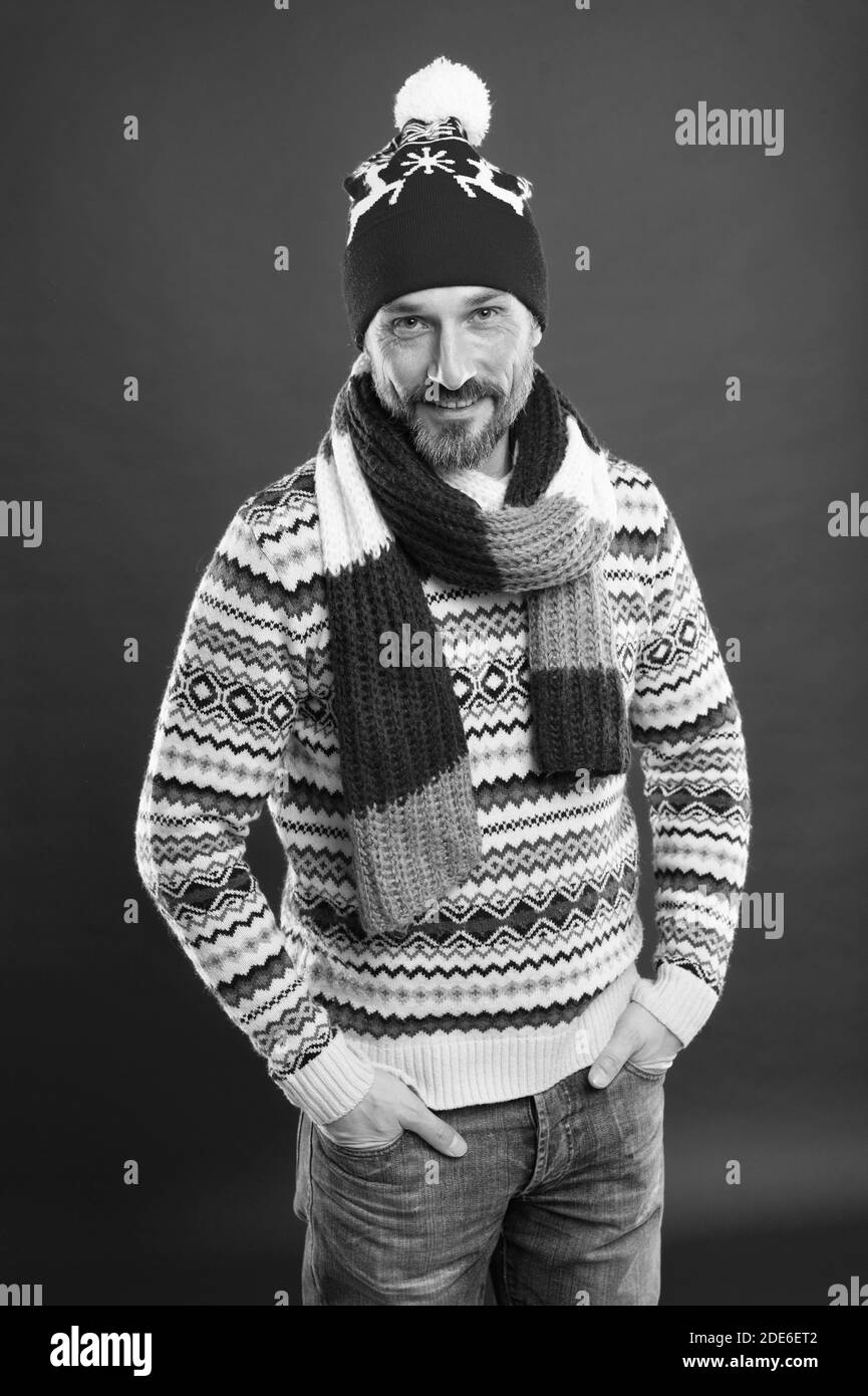 Express Positivität. männliche Fashion Kollektion. Reifer mann Komfort genießen können. Weihnachten Zeit. In neuen Jahr Stimmung. Happy bärtiger Mann roten Hintergrund. Gestrickte Zubehör. kaltem Wetter Trends. Stockfoto