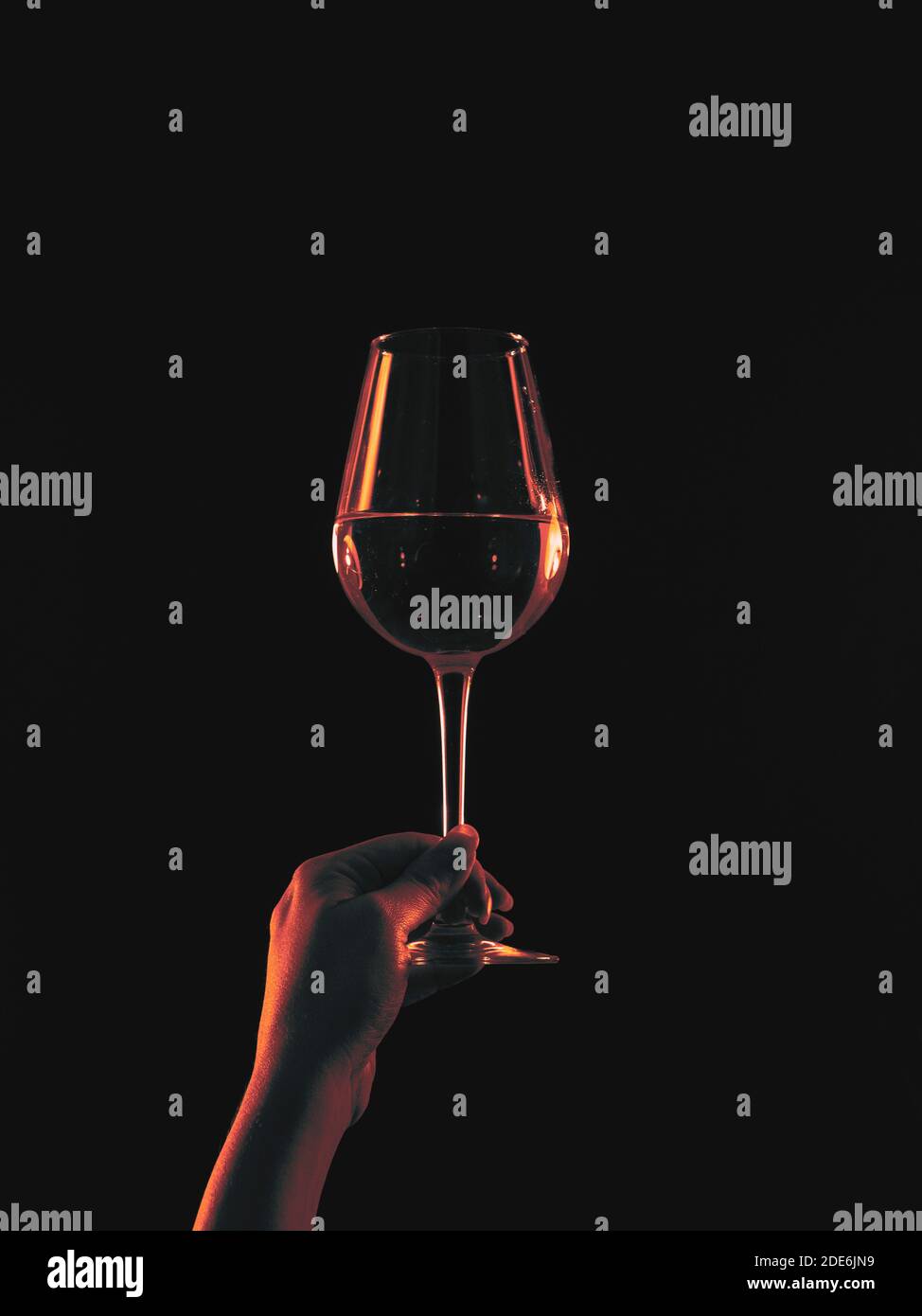 Frau hält Weinglas im Randlicht Stockfoto
