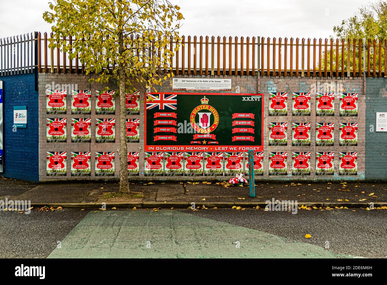 Ein Wandgemälde in der Beverley Street, Belfast, Nordirland, erinnert an die 36. (Ulster) Division der britischen Armee des Ersten Weltkriegs und listet die Schlachtnamen Somme 1916, Messines 1917, Ypern 1917, Cambrai 1917, die deutsche Frühjahrsoffensive von 1918, Lys 1918 und Courtrai 1918 auf; Reihen von roten Gedenktafelblumen mit den Namen der Gefallenen umgeben das zentrale Feld unter den Worten „In glorreicher Erinnerung – Wir werden nicht vergessen“. Die hauptsächlich aus Mitgliedern der Ulster Volunteers gebildete Division erlitt am ersten Tag der Schlacht an der Somme im Jahr 1916 schwere Verluste. Stockfoto