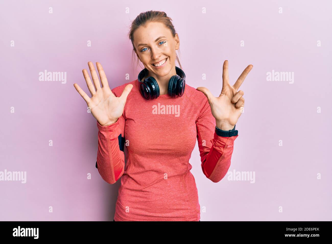 Schöne kaukasische Frau trägt Sportkleidung und Armband zeigt und zeigt mit den Fingern Nummer acht, während lächelnd zuversichtlich und glücklich. Stockfoto