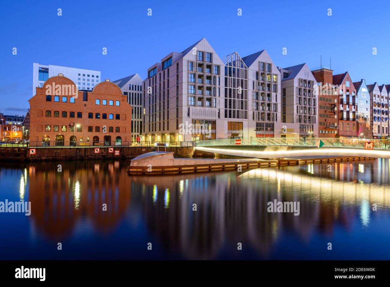 Fußgängerbrücke über den Fluss Motlawa und moderne Architektur der Kornspeicher Insel in Danzig bei Nacht. Polen Stockfoto