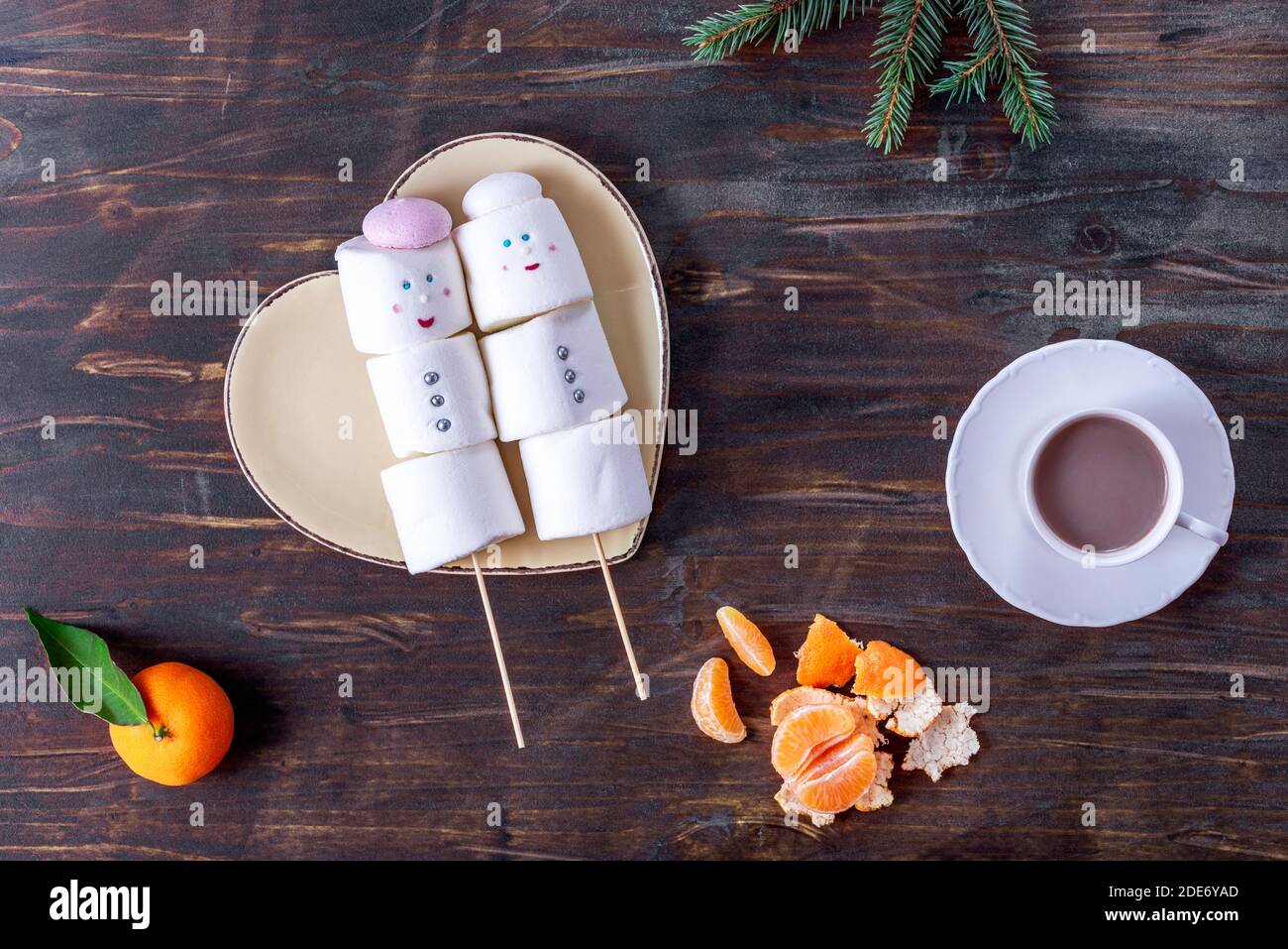 Niedliche Marshmallow Schneemänner auf dem herzförmigen Teller Stockfoto