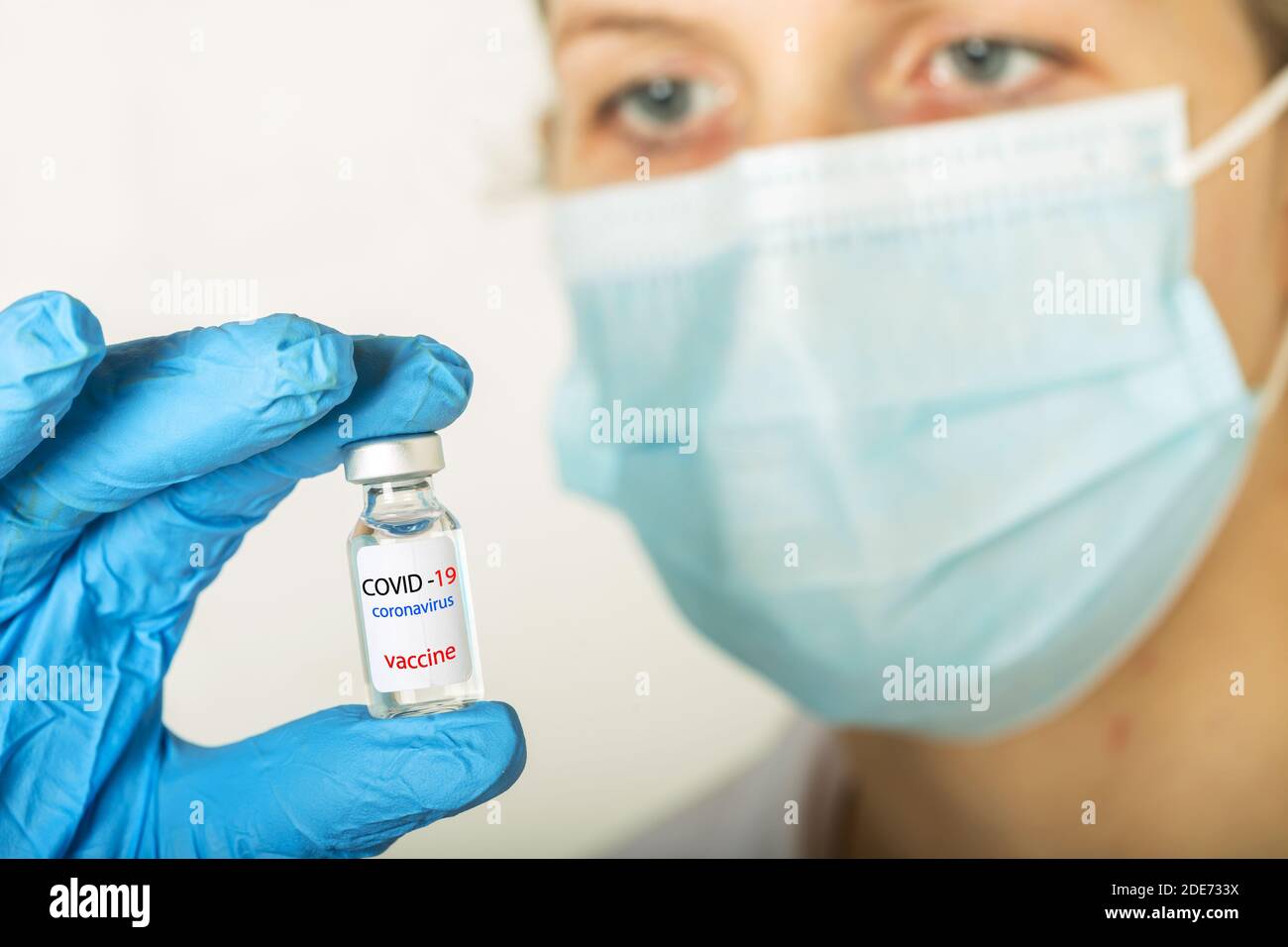 Entwicklung und Schaffung eines Coronavirus-Impfstoffs COVID-19 .Coronavirus-Impfstoff In der Glasflasche in der Hand des Arztes blau Impfstoff-Glas Auf weißem Hintergrund Stockfoto