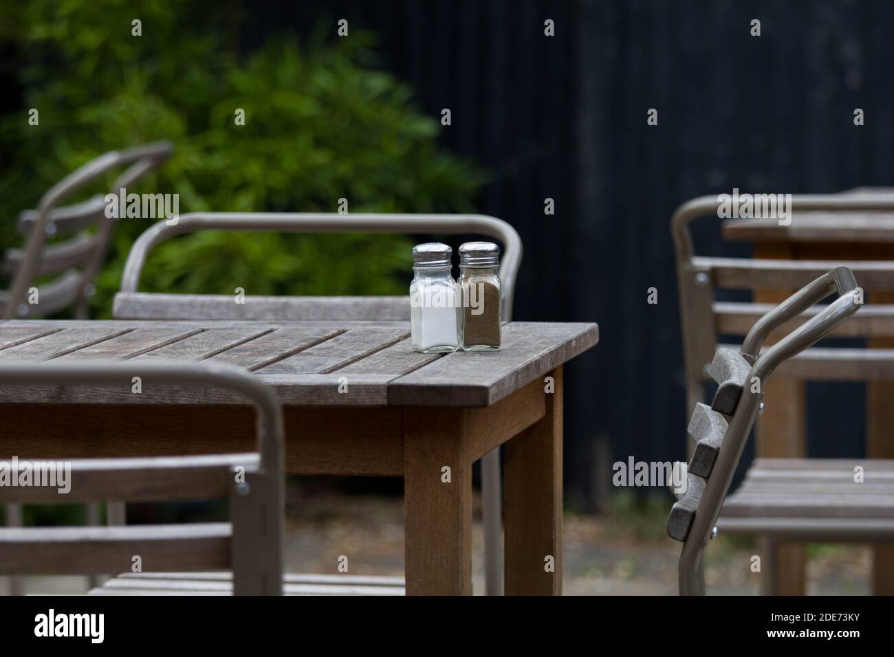 Verlassene Cafeteria mit einsamen Salz- und Pfefferköpfen, die den Verlust von Brauch- und Gastgewerbeschließungen symbolisieren. Pandemiefolgen. Stockfoto