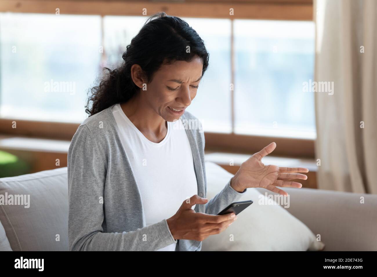 Wütend biracial Frau mit Problemen mit Smartphone Stockfoto