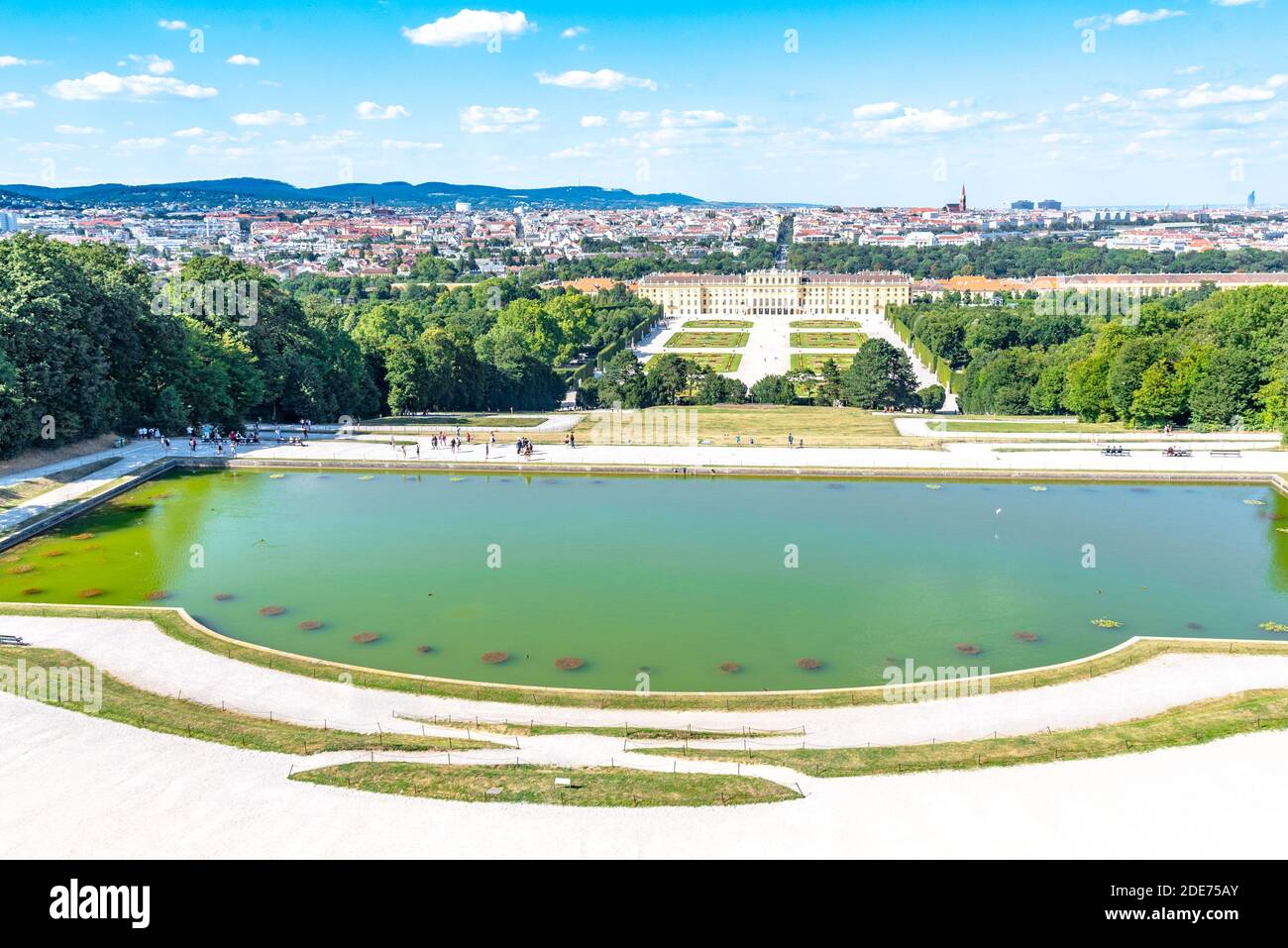 WIEN, ÖSTERREICH - 23. JULI 2019: Schloss Schönbrunn, Deutsch - Schloss Schönbrunn, und großer Parterre - Französischer Garten mit schönen Blumenbeeten. Blick von der Gloriette. Wien, Österreich. Stockfoto