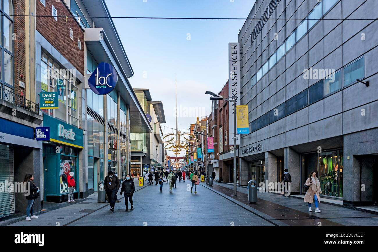 Henry Street Dublin, Irland, alle verkleidet und bereit für das Holiday Festival Shopping mit dem Spire Monument im Hintergrund. Stockfoto