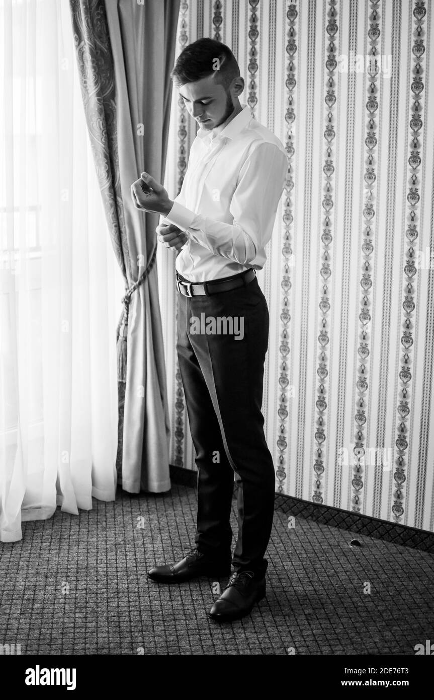 Morgen des Bräutigams. Der Bräutigam knöpfte die Manschettenknöpfe auf seinem Hemd Stockfoto