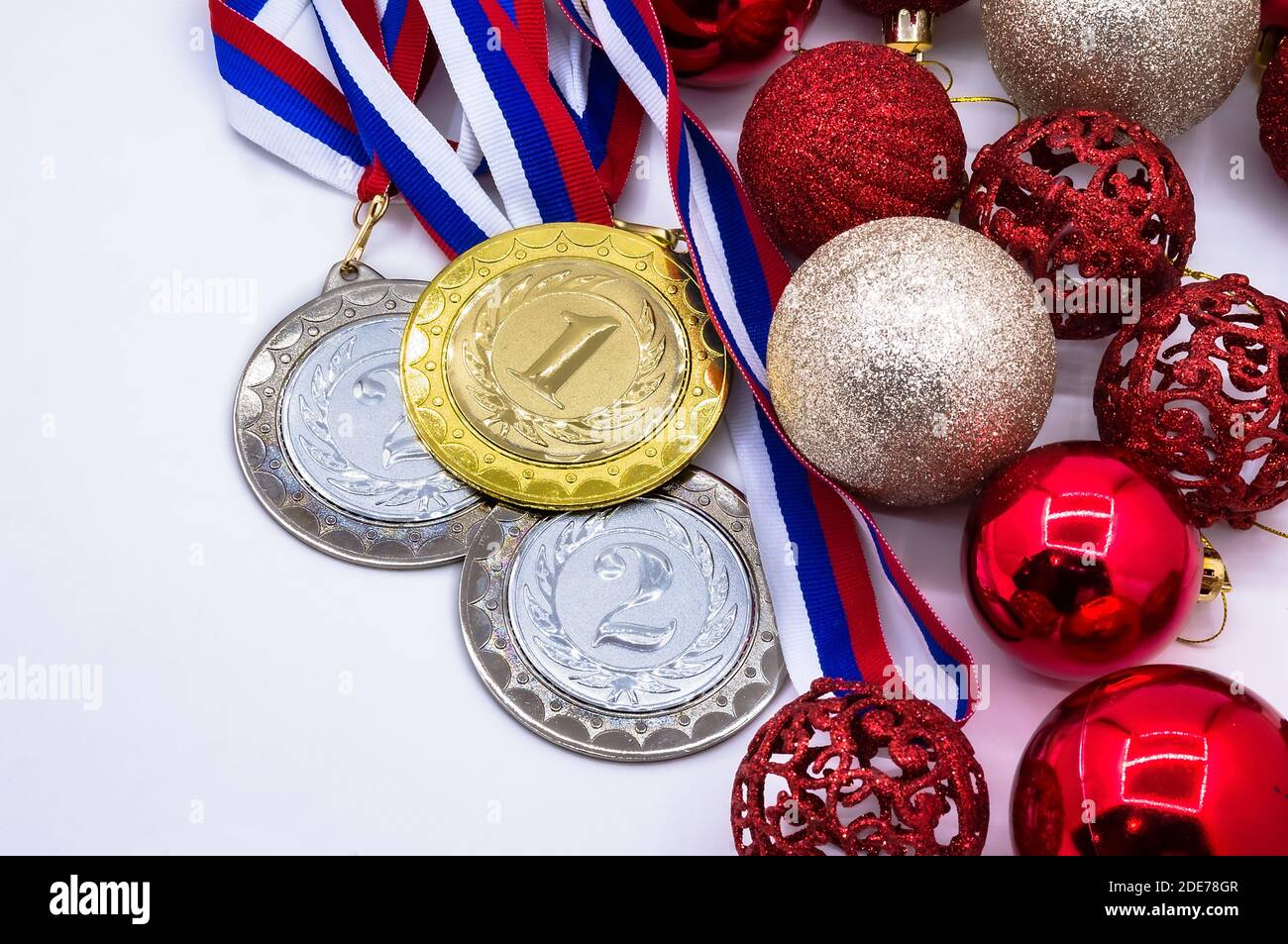 Winterwettbewerbe, Neujahr, Sportmedaille und rote Weihnachtsbälle, Sportpreis und Weihnachtsspielzeug Stockfoto