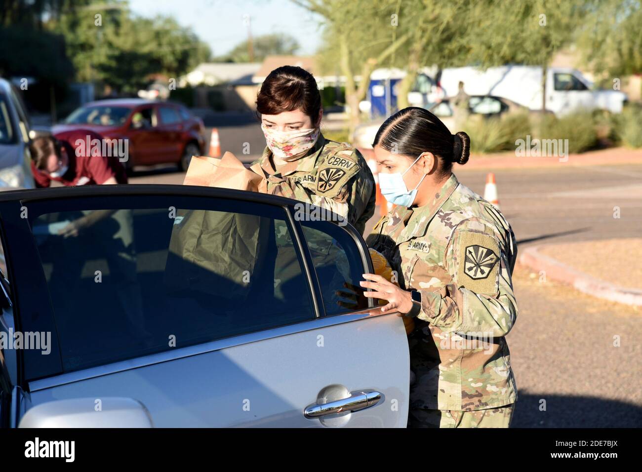 Dienstmitglieder der Arizona National Guard liefern den Bewohnern an einer Lebensmittelbank am 19. November 2020 in Casa Grande, Arizona, Lebensmittel. Die Pandemie hat zu einer Zunahme der Ernährungsunsicherheit geführt, da die Nahrungsmittelbanken im ganzen Land lange Schlangen haben. Stockfoto