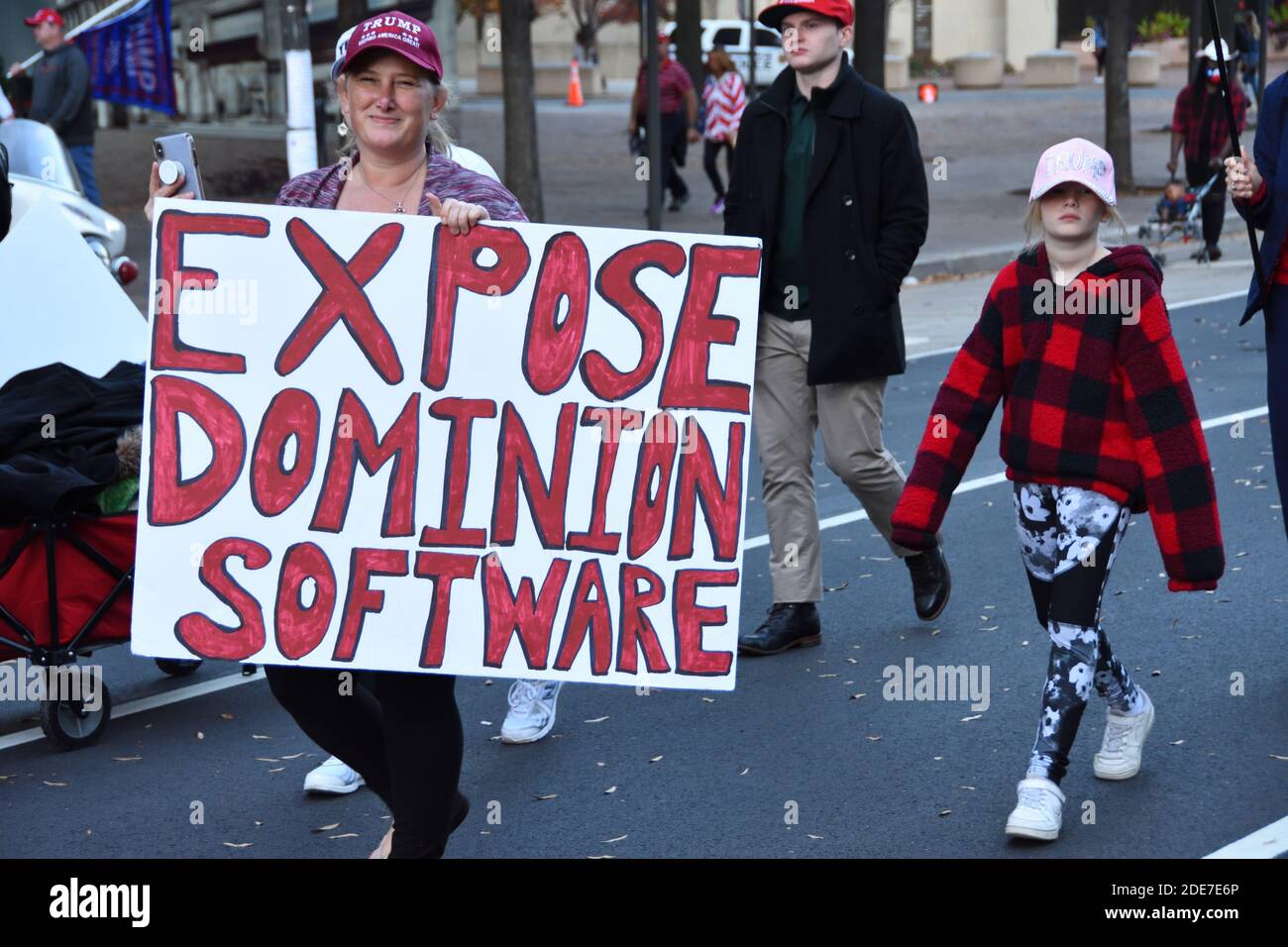 Washington DC. 14. November 2020. Million Mega March. Eine Frau Trumps Unterstützer, die mit dem politischen Schild „Expose Dominion Software“ auf der Straße läuft. Stockfoto