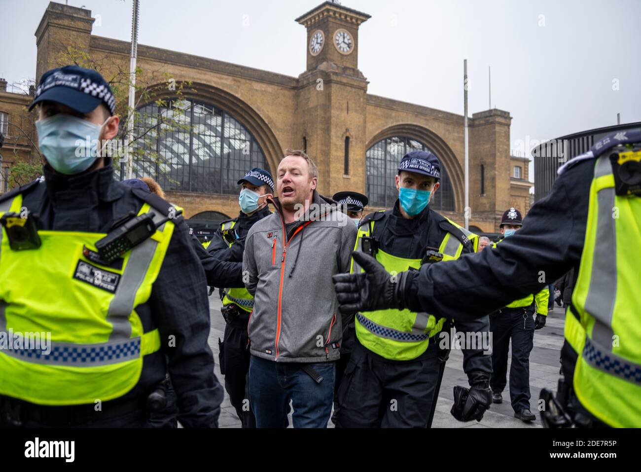 Die Polizei verhaftete einen Protestierenden vor der Kings Cross Station bei einem COVID 19 Coronavirus Anti-Lockdown-protestmarsch in London, Großbritannien, weil er draußen war Stockfoto