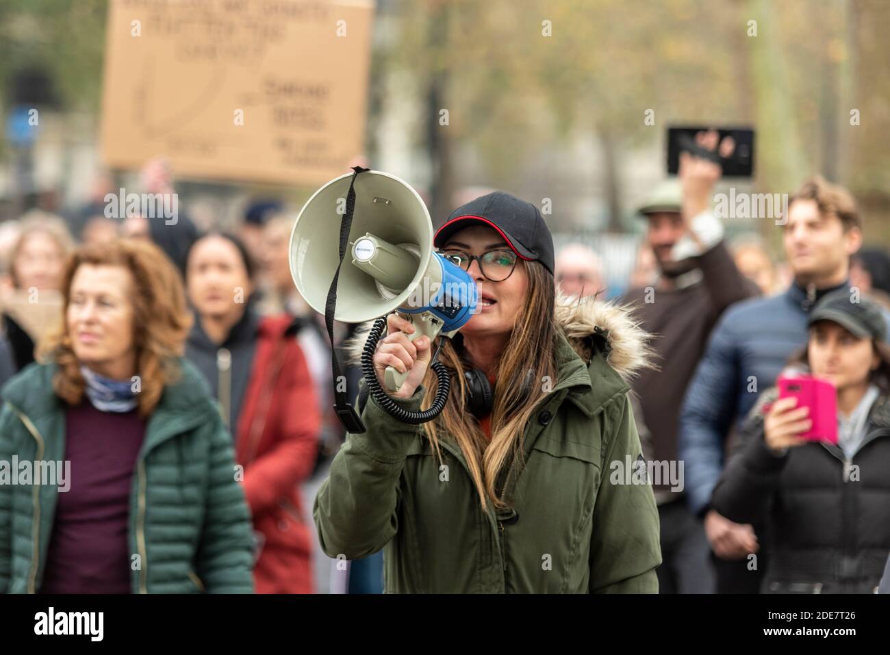 Weiße kaukasische Frau schreit durch ein Megaphon auf einem COVID 19 Coronavirus Anti-Lockdown-protestmarsch in London, Großbritannien. Illegale Erfassung Stockfoto