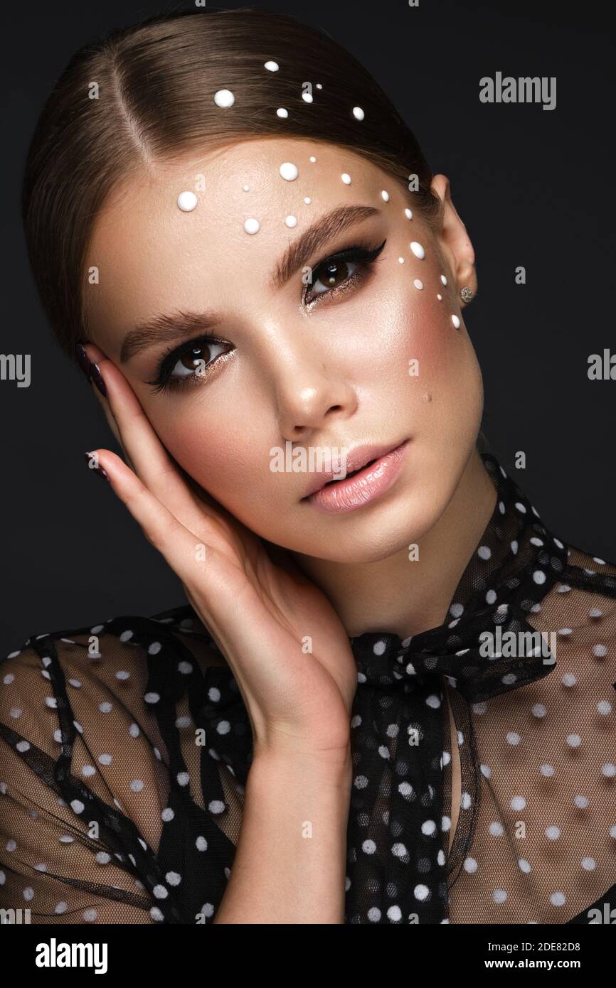 Portrait einer schönen Frau in einem schwarzen Kleid mit Perlen und klassischem Make-up. Stockfoto