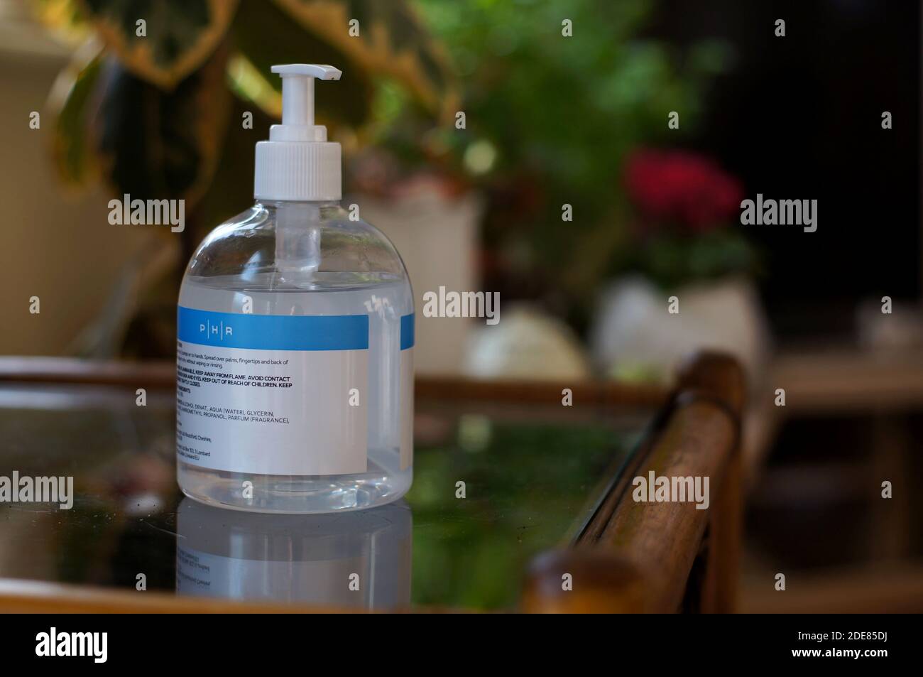 Handdesinfektionsflasche auf einem Tisch im Wohnzimmer mit weichem Fokus Hintergrund Stockfoto