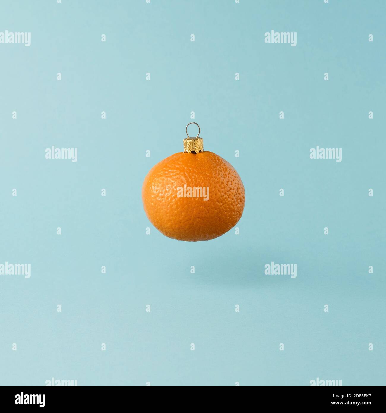 Weihnachtsspielzeug aus orangefarbener Mandarinenfrucht. Minimales Neujahrs-Konzept. Levitation. Stockfoto