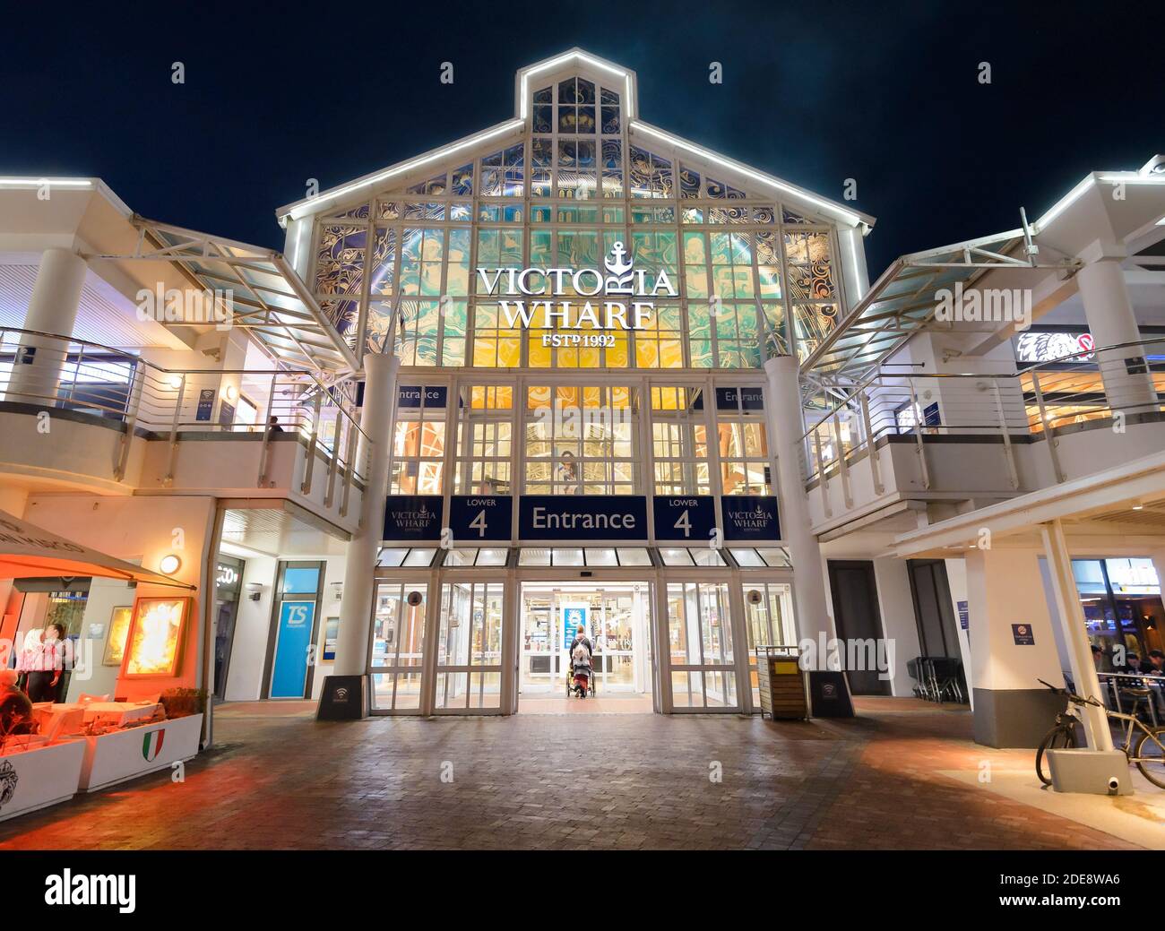 Victoria Wharf Shopping Mall Eingang in Victoria & Alfred Waterfront in Cpae Town, Südafrika. Gehobene Mall bei Nacht. Stockfoto