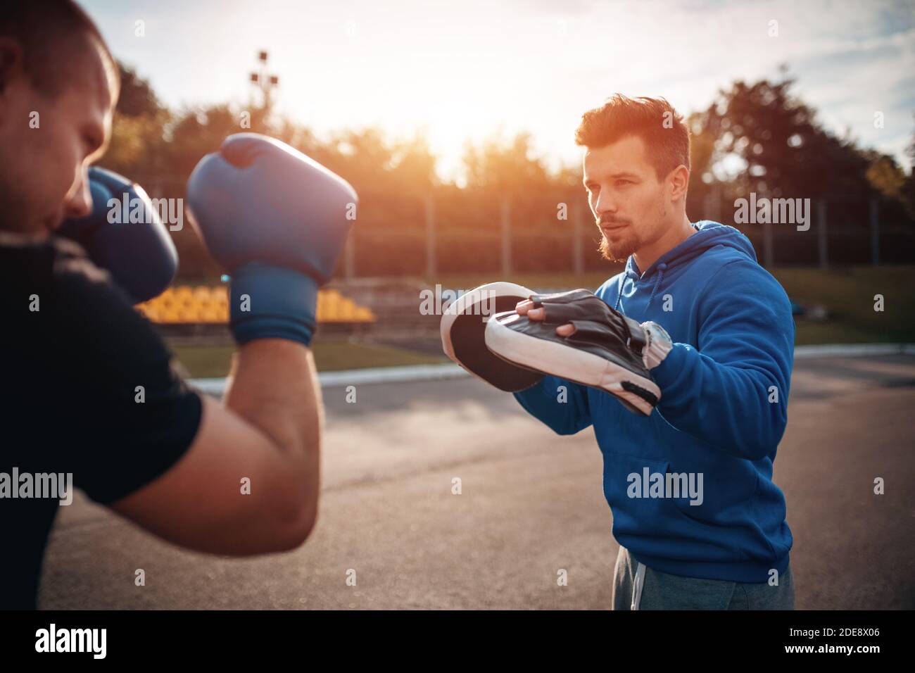 Sport Mann Boxer Training in Boxhandschuhen mit Personal Trainer Im Freien Stockfoto