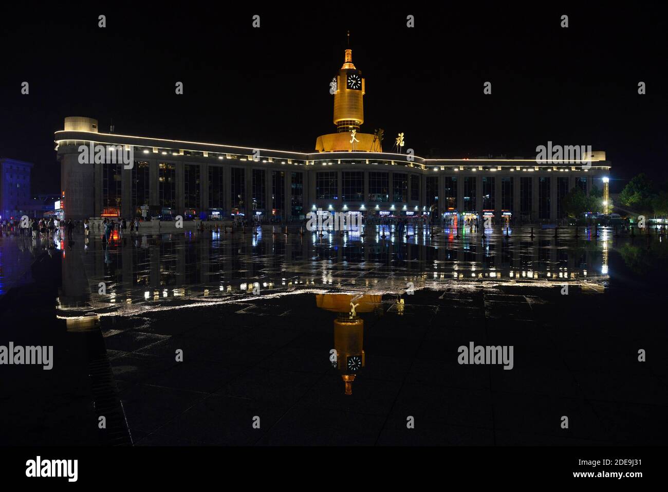 Die Tianjin-Station spiegelt sich in stehendem Wasser auf der Bahnhofsebene nach einem heftigen Regensturm wider. Tianjin, China Stockfoto