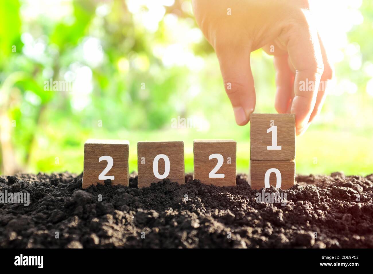 Männliche Hand begraben Jahr 2020 auf 2021 in Holzklötze Würfel ändern. Neujahr, Hallo und Auf Wiedersehen Konzept. Stockfoto