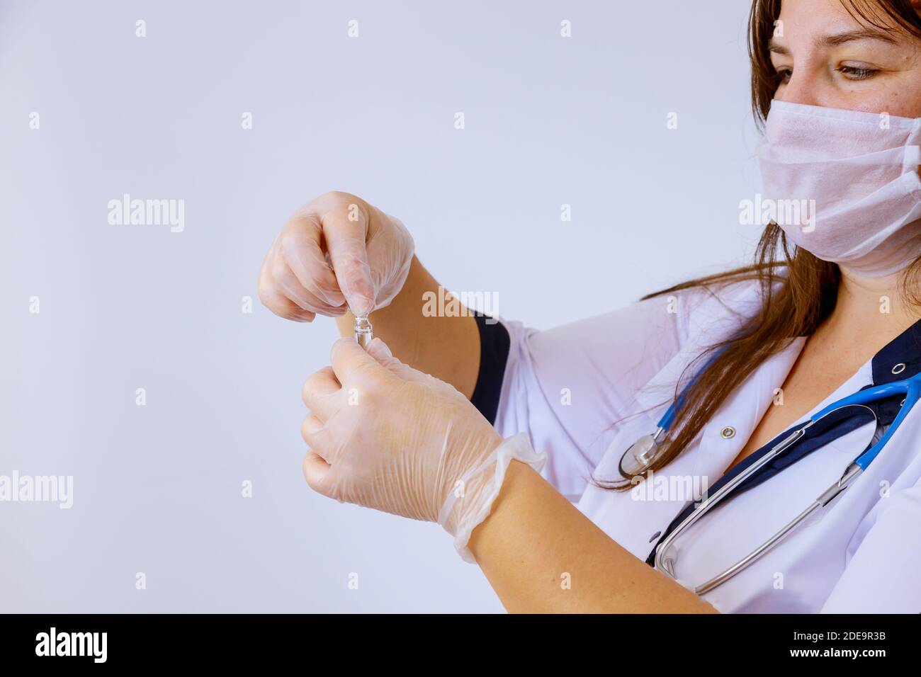 Das Medikament Handschuhe Arzt hält eine Ampulle für die Impfung Behandlung In seiner Hand konzentrieren sich auf die Ampulle Stockfoto