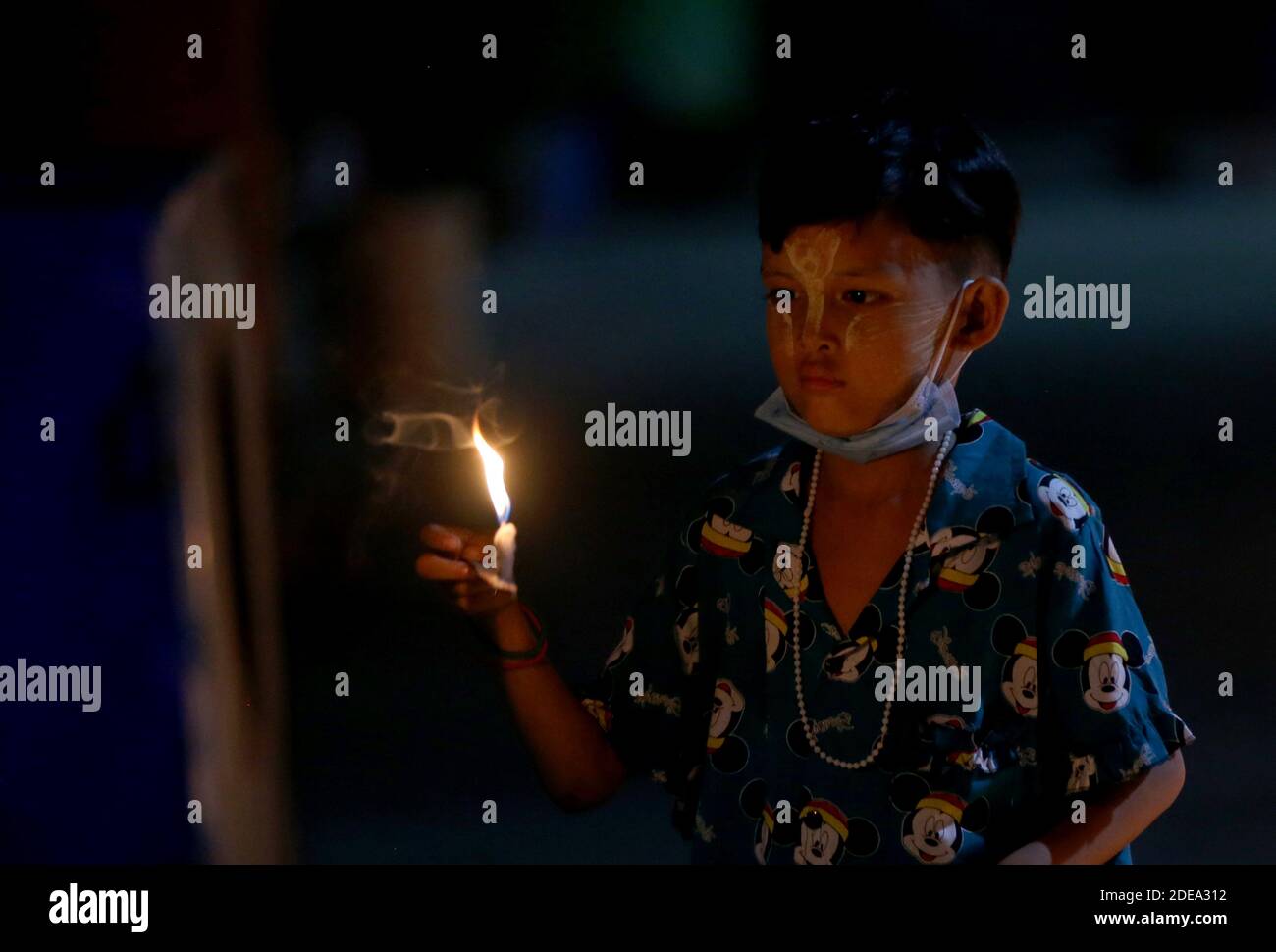 Myanmar, Myanmar. November 2020. Ein Kind zündet während des traditionellen Tazaungdaing Festivals in Yangon, Myanmar, am 29. November 2020 eine Kerze an. Das Tazaungdaing Festival, auch bekannt als das Festival der Lichter, fällt auf den Vollmondtag im achten Monat des traditionellen Myanmar Kalenders. Es wird als Nationalfeiertag in Myanmar gefeiert und markiert das Ende der Regenzeit. Quelle: U Aung/Xinhua/Alamy Live News Stockfoto