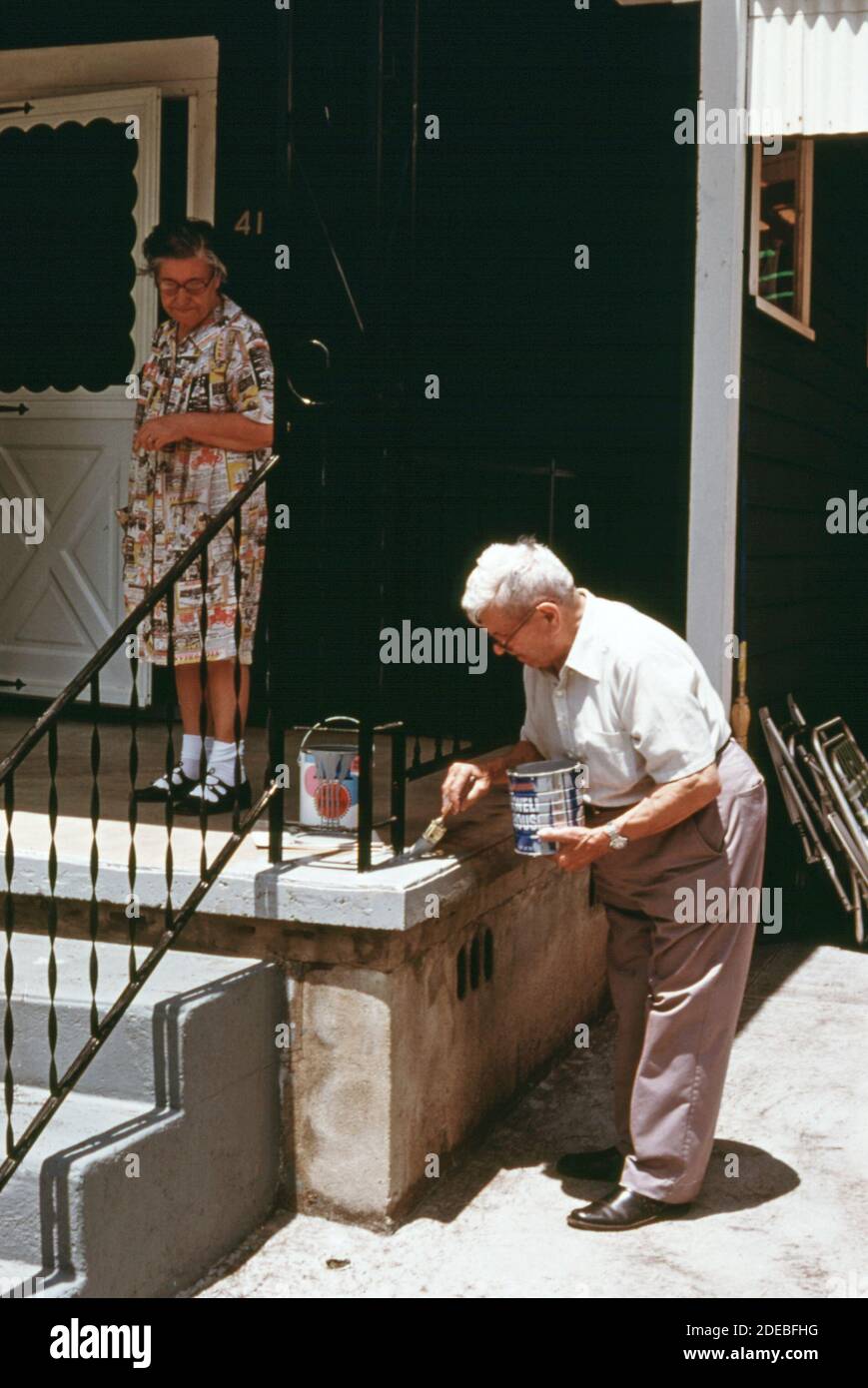 1970er-Jahre Foto (1975) - Porch bekommt einen Anstrich an einem Haus in Boomer West Virginia, das von dem älteren Paar auf dem Bild besetzt ist. Stockfoto