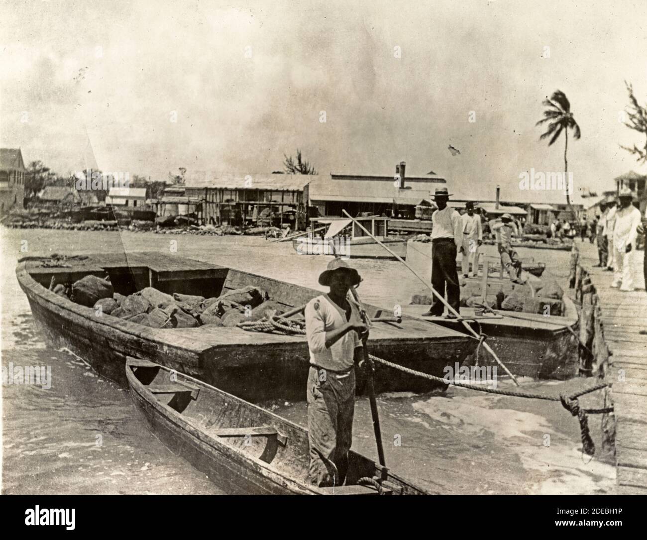 Landeschikel - Foto zeigt Männer mit Barge-Ladungen gebündelter Chicle-Blöcke in Belize Harbour, 1919 Stockfoto