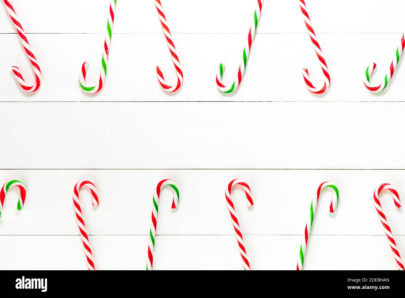 Bunte Weihnachten Süßigkeiten Zuckerrohr Süßigkeiten auf weißem Holz Hintergrund mit Platz in der Mitte kopieren Stockfoto