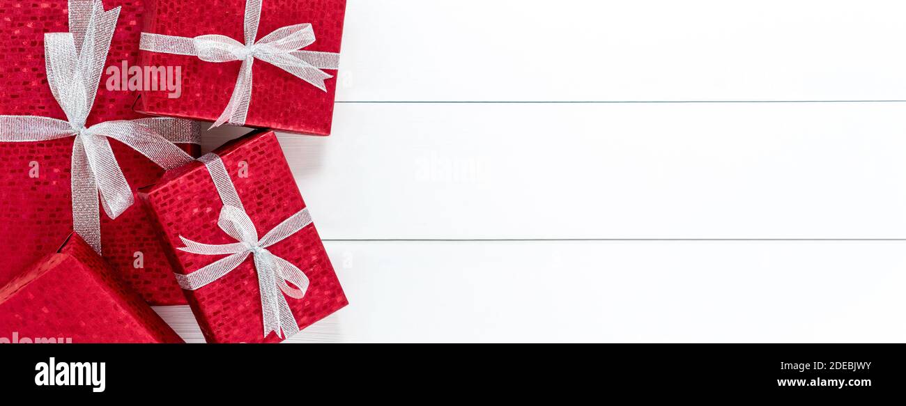 Gruppe von roten Weihnachtsgeschenkboxen auf weißem Holz Banner Hintergrund Rahmen Design mit Kopieplatz Stockfoto