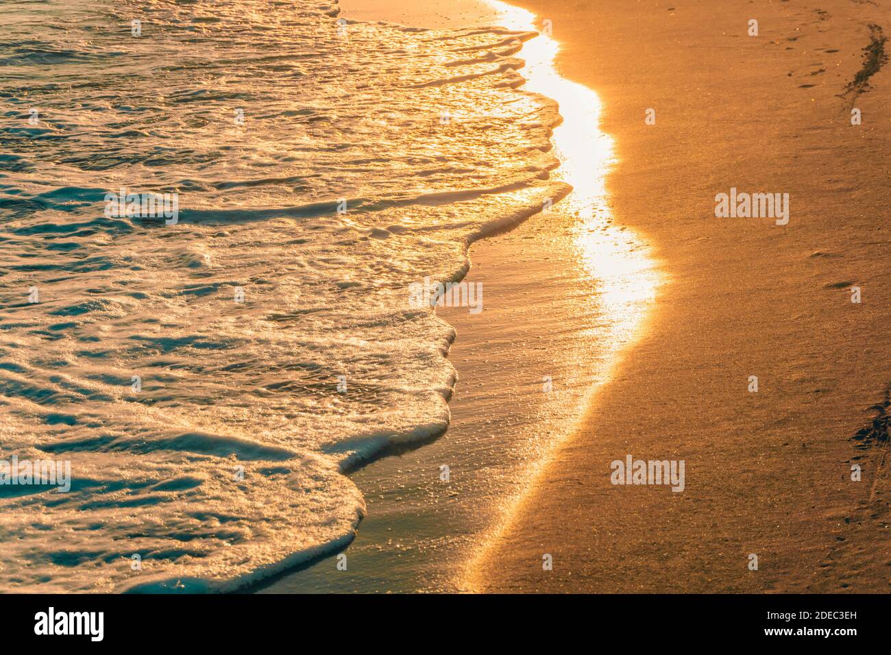 Bei Sonnenuntergang leuchten die Sonnenlichter auf den Wellen. Goldene Töne. Stockfoto