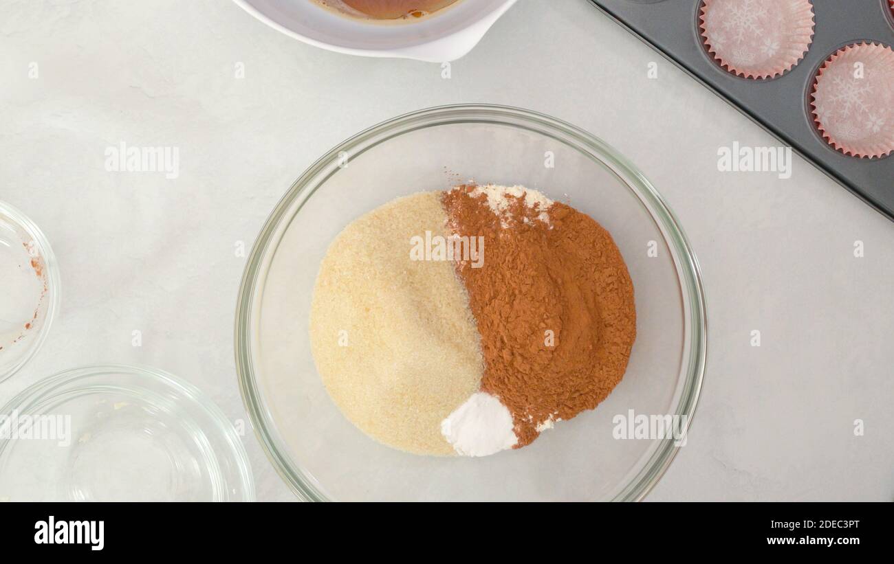 Schokoladenmuffins Rezept. Mischen Sie trockene Zutaten - Mehl, Zucker, Kakaopulver, Backpulver - in einer Glasschüssel Stockfoto