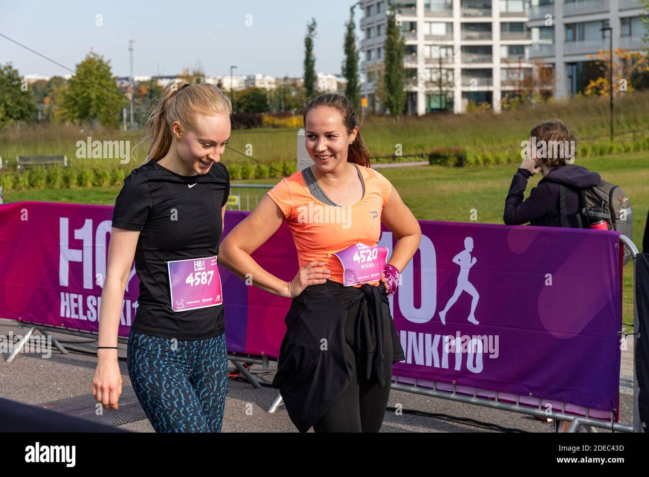 Junge Frauen nach dem Überqueren der Ziellinie des Helsinki10- oder H10-Laufwettbewerbs in Helsinki, Finnland Stockfoto