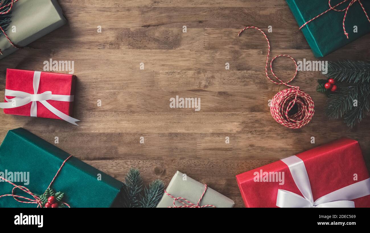 Draufsicht auf bunt dekorierte Geschenkschachteln auf Holztisch Border Design Weihnachten Hintergrund mit Kopierplatz in der Mitte Stockfoto