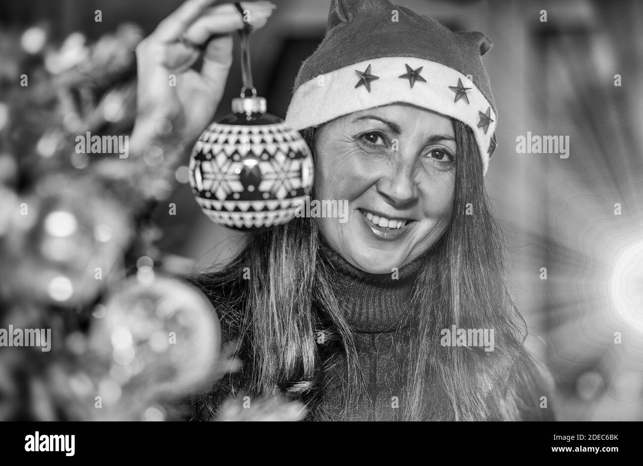 Glückliche Brünette Frau Dekoration Weihnachtsbaum zu Hause, halten Red Christmas Ball. Stockfoto