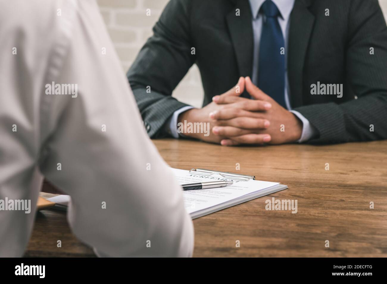 Geschäftspartner, der eine Vertragsvereinbarung mit dem Dokument auf dem Tisch abgibt Im Büro Stockfoto