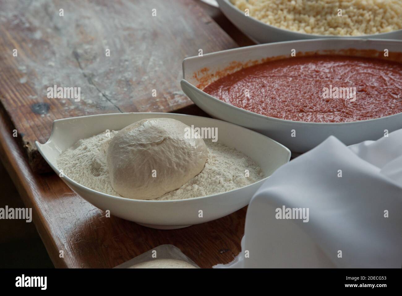 Vorbereiten und Backen einer Focaccia Pizza mit Tomatenmark und Käse Stockfoto